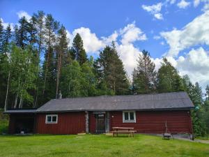 a red barn with a picnic table in front of it at Lilla Åsbo Gård in Husvallsgölen