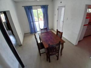 a dining room with a wooden table and chairs at cabañas cosquin in La Porteña