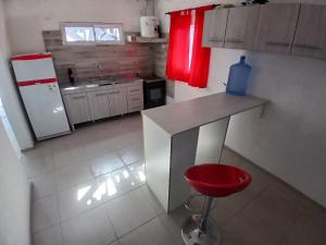 a kitchen with a counter and a red stool in it at cabañas cosquin in La Porteña