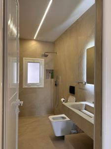 a bathroom with a toilet and a sink and a shower at Kanaj Rooms and Apartments in Vlorë