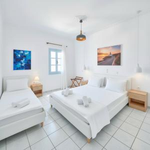 two beds in a room with white walls at Lume d'Oro Syros in Kini