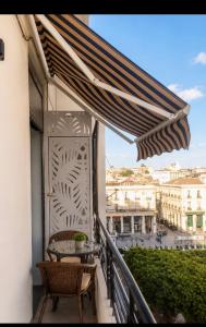 a balcony with a table and chairs and an umbrella at Appartement LA SCENE DU CENTRE ANNABA in Annaba