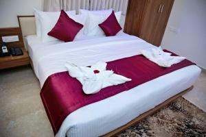 a bed with two white flowers on it at Star Light Suites in Bangalore +7 photos
