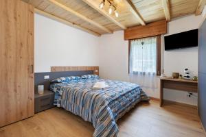 a bedroom with a bed and a desk and a television at Casa Aria Pura in Alano di Piave