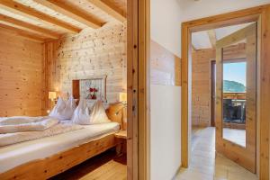a bedroom with a bed in a wooden wall at Schwabl Auf Der Ebene in Meltina