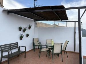 a patio with a table and chairs and a bench at El Redoble de Moratalla in Moratalla