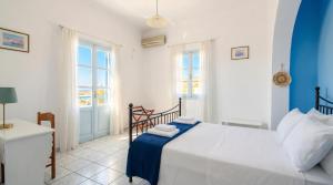 a bedroom with a bed with blue and white at Lume d'Oro Syros in Kini