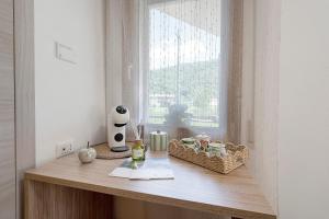 a table with a window with baskets of food and a vase at Casa Aria Pura in Alano di Piave