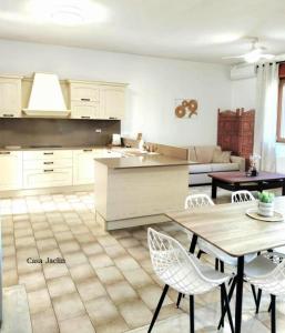 a kitchen with white cabinets and a table and chairs at Appartamento Mancaversa Centro, 200m mare in Marina di Mancaversa
