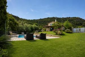 a yard with a swimming pool and a house at Blue Jasmine Villa - Private Pool and Garden in Aigio +38 photos