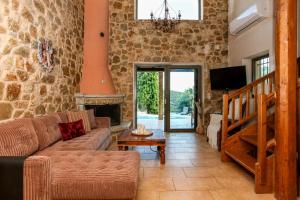 a living room with a couch and a fireplace at Blue Jasmine Villa - Private Pool and Garden in Aigio