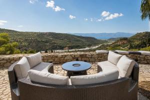 a patio with couches and a table with a view at Blue Jasmine Villa - Private Pool and Garden in Aigio