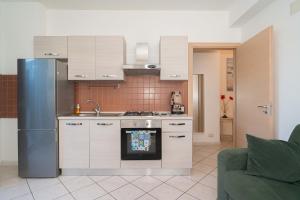 a kitchen with white cabinets and a refrigerator at New Naxian Holidays in Giardini Naxos