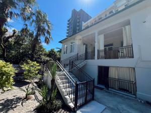 a white house with stairs and a balcony at Resort In Gonio in Kvariati