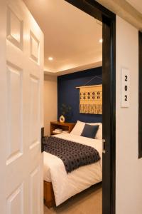 a bedroom with a bed with a blue wall at La Vie Résidence in Chiang Mai
