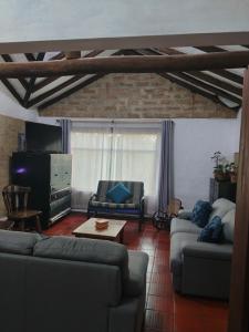 a living room with two couches and a tv at Hospedaje Casa Campestre Pistacia Vera - Villa de Leyva in Villa de Leyva
