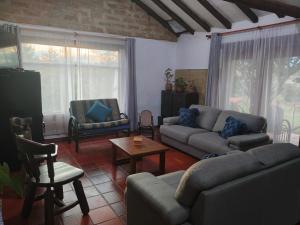 a living room with a couch and a table at Hospedaje Casa Campestre Pistacia Vera - Villa de Leyva in Villa de Leyva