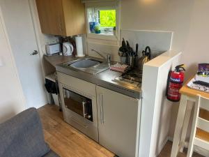 a small kitchen with a sink and a stove at Marbury Camp and Lodge in Whitchurch