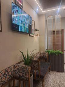 a waiting room with a couch and a tv on the wall at hotel manjushree in Pachmarhī