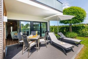 a patio with a table and chairs and an umbrella at FeWo Lieblingsplatz in Zingst