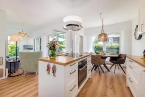 a kitchen with white cabinets and a table with chairs at FeWo Lieblingsplatz in Zingst