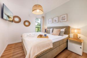 a bedroom with a large bed and a television at FeWo Lieblingsplatz in Zingst