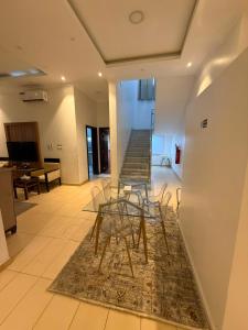 a room with a table and chairs and a staircase at جراند سيزون للشقق الفندقية الخبر Grand Season Hotel Apartments in Al Khobar in Al Khobar