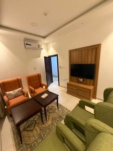 a living room with a couch and two chairs and a tv at جراند سيزون للشقق الفندقية الخبر Grand Season Hotel Apartments in Al Khobar in Al Khobar