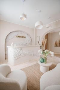 a living room with a piano and two chairs at AMAREA BOUTIQUE Hotel in Eforie Sud