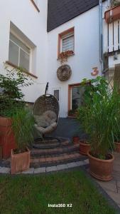 a patio with a chair in front of a house at Pension Martin Zimmer & Apartment in Bad Camberg +3 photos