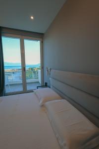 a bedroom with a bed with a large window at The Real Sea View Hotel Vlore in Vlorë
