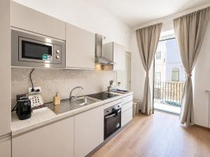 a kitchen with a sink and a microwave at Maison Arche' relax e spazio a Sannicandro in Sannicandro di Bari