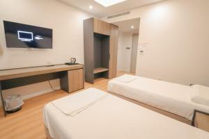 a hotel room with two beds and a tv at The Real Sea View Hotel Vlore in Vlorë +41 photos