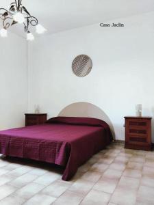 a bedroom with a bed with a purple blanket at Appartamento Mancaversa Centro, 200m mare in Marina di Mancaversa +24 photos