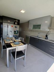a kitchen with a table with chairs and a sink at Casa Estradinha Azul in Amarante