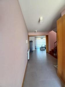 a living room with a white wall and a hallway at Casa Estradinha Azul in Amarante