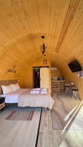 a bedroom with two beds and a wooden ceiling at Swallow in Karakol