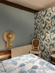 a bedroom with a bed and a hat on the wall at Chambre d'Hôte des Arcs in Coulonces