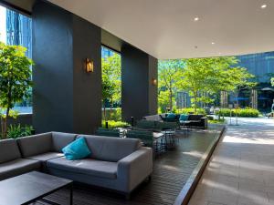 a lobby with couches and tables in a building at STAR Residence KLCC - Dreamland Holiday Home in Kuala Lumpur