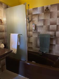 a bathroom with a shower with a tub and a towel at Chambre d'Hôte des Arcs in Coulonces +39 photos