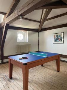a ping pong table in the middle of a room at Chambre d'Hôte des Arcs in Coulonces