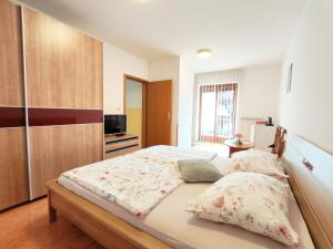 a bedroom with a large bed and a kitchen at Rooms Čehovin in Postojna