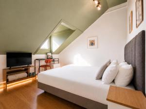 a bedroom with a large bed and a tv at Happy Holiday Sintra Guesthouse & Breakfast in Sintra