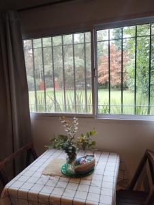 a table with a vase on it in front of a window at La Adelita in Chascomús +17 photos