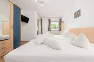 a bedroom with two white beds and a television at Haus St. Christoph in Mayrhofen