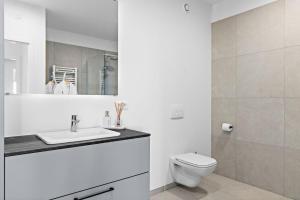a white bathroom with a toilet and a sink at Premium Ice Apartments Atlantic Ocean Magic View in Reykjavík +87 photos