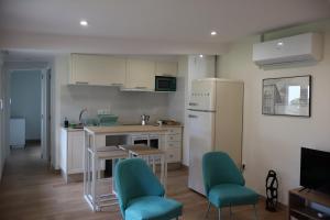 a kitchen with a table and chairs and a refrigerator at Xeitosa II, en el centro de Vigo in Vigo