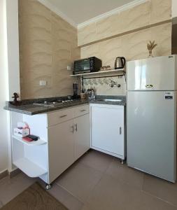 a kitchen with white cabinets and a white refrigerator at Remas resort in El Alamein +12 photos