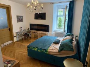 a bedroom with a bed and a desk and a chandelier at Downtown luxury segment in Braşov