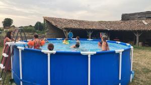 a group of children playing in a blue pool at Maison Mélusine in Londigny